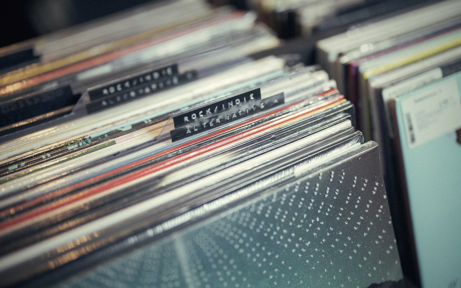 Vinyl records sorted in a crate with a rock/indie/alternative genre divider