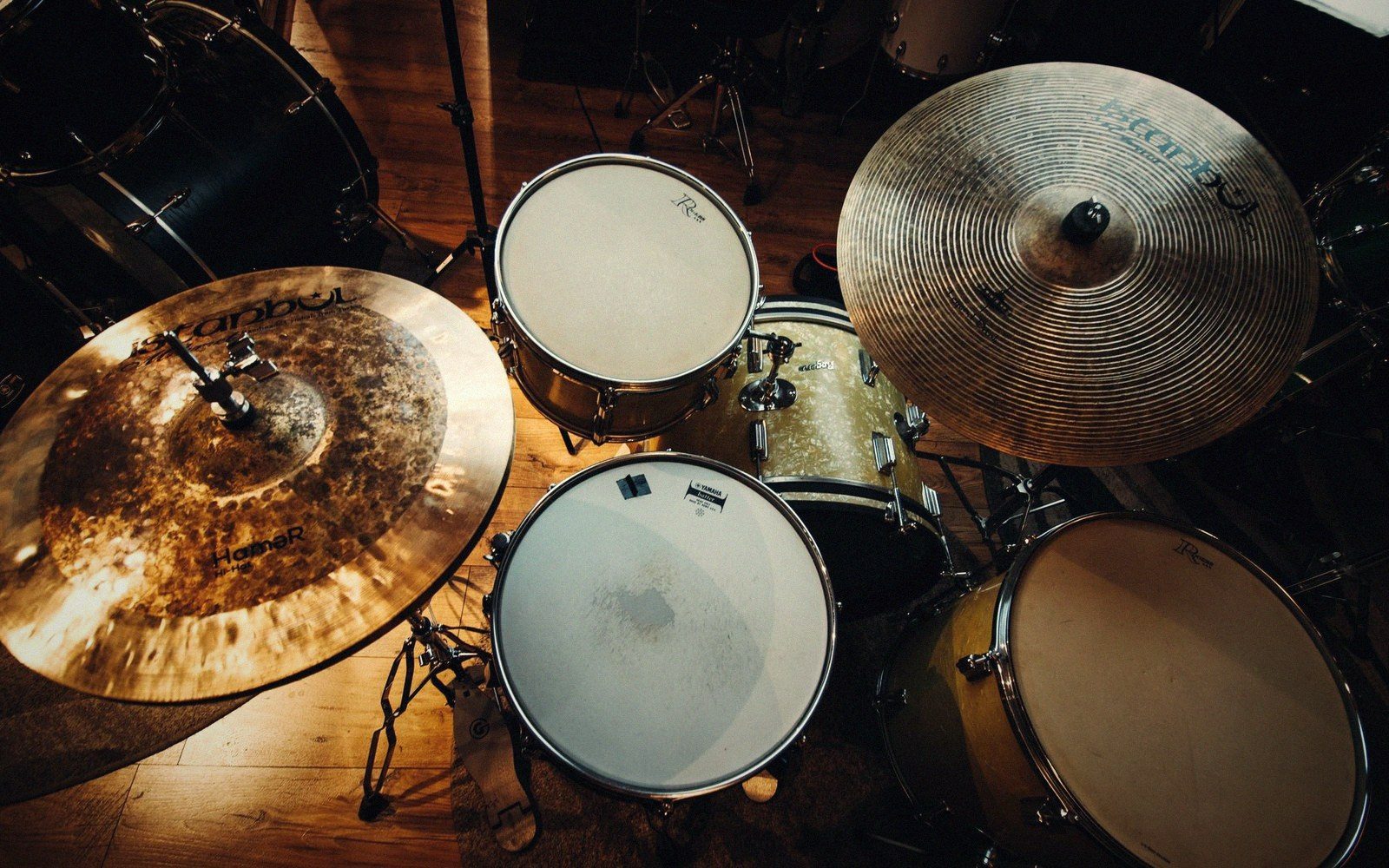 Overhead view of a drum kit showing cymbals, snare and toms on a wooden floor